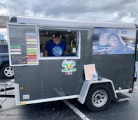 a man is standing in front of a food truck